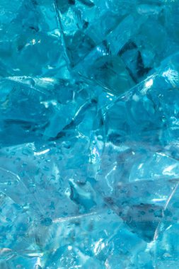 Mavi buz kristallerinin dokusu ve arkaplanı tatlı su damlalarında. Donuk, taze bir geçmiş. Klasik mavi arka plan. Dekoratif mavi bardağın makro fotoğrafı..