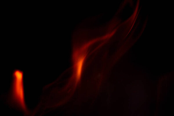 Beautiful fire flame on a black background. Abstract blurred fire. orange-red flames closeup.