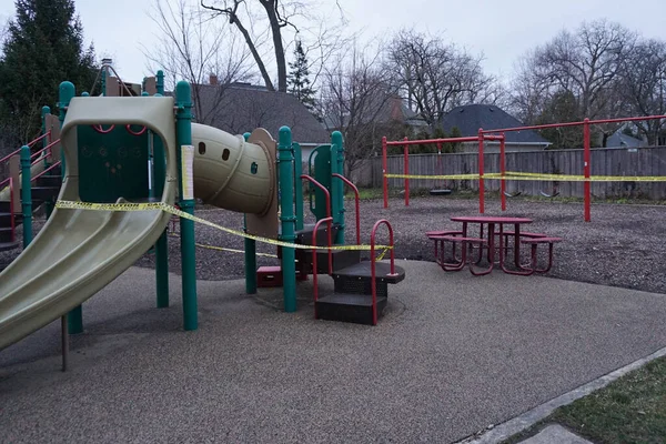 Koronavirüs salgını sırasında sakinlerin ekipmanları kullanmasını engellemek amacıyla Chicago 'nun banliyölerindeki bir oyun alanını çevreleyen bir teyp kaseti. Mart ayı ortasında valinin emriyle sığınma emri verildi..