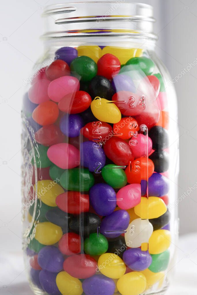 Colorful jelly beans fill a glass jar