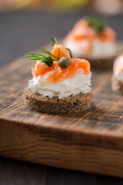 Krem peynirli mini sandviçler, füme somon, kapari ve dereotlu.