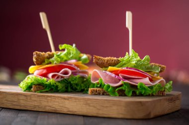 Salata, jambon, peynir ve domatesli kahvaltı sandviçi.