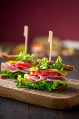 Salata, jambon, peynir ve domatesli kahvaltı sandviçi.