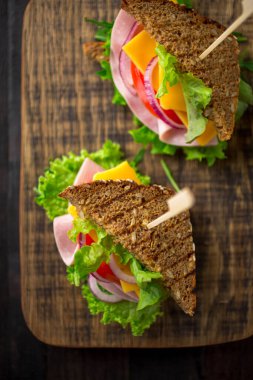 Salata, jambon, peynir ve domatesli kahvaltı sandviçi.