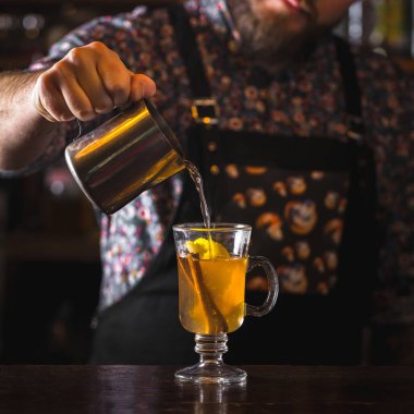 Barmen klasik sıcak kokteyl hazırlıyor.