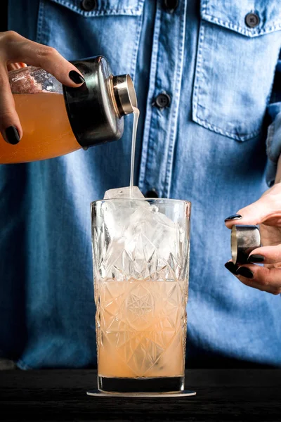 bartender pours grapefruit drink from the shaker