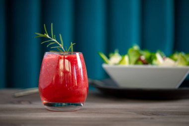 Arka planda salata olan çilekli limonata kokteyli.