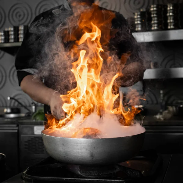 chef in action with a frying pan on high heat Stock Image Everypixel