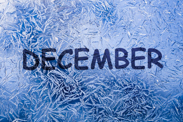 December text on frozen patterned glass.on winter window.