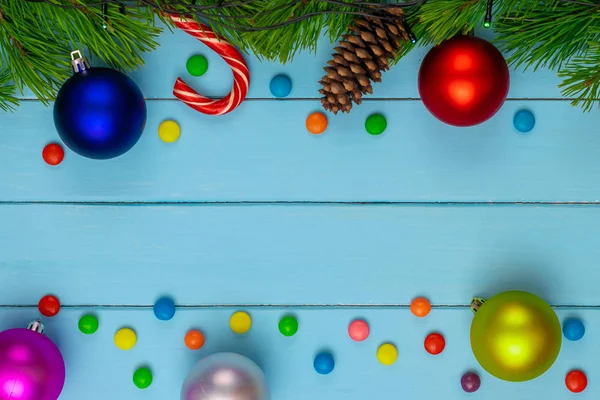 Christmas back,ground, green fir branches, red and blue, pink, yellow, ball, candies, cone, blue boards