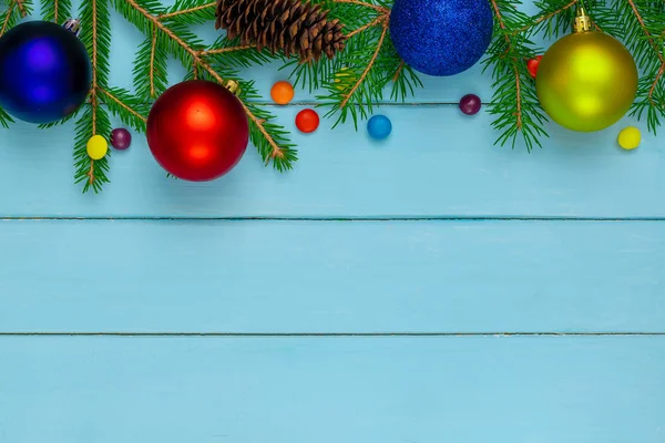 Christmas back,ground, green fir branches, red and blue, yellow, ball, candies, cone, blue boards