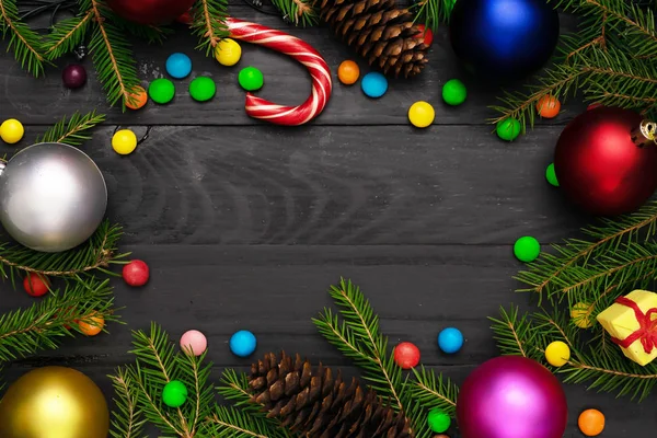 Christmas back,ground, green fir branches, red and blue , golden balls, candies, cone, gift box, black boards