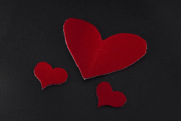 Two Small Large Red Hearts Black Skin Close — Stock Photo, Image