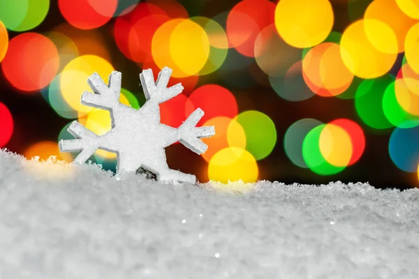 stock image figure snowflakes in the snow. with colorful Christmas round the side bokeh