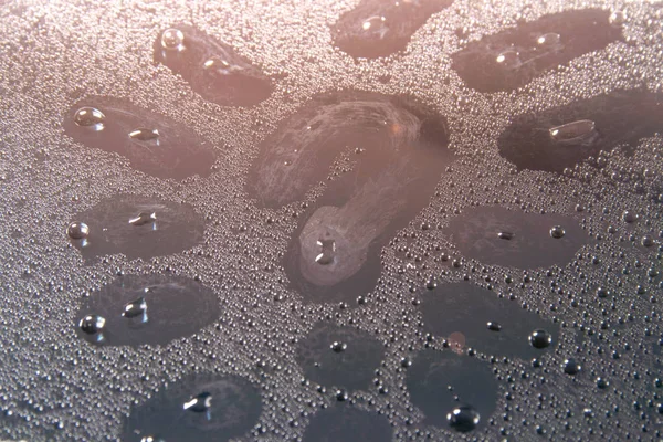 question mark on the wet glass water Droplets glistening in the rays of light closeup, texture