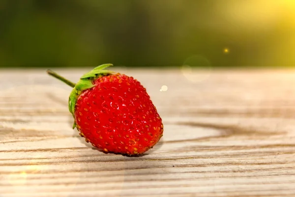 One Strawberry Wooden Table Green Bokeh — Stock Photo, Image