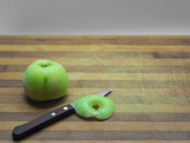 Yeşil Elma bir bütün ve tahta bir tahta üzerinde dilimler, bir bıçak ile w