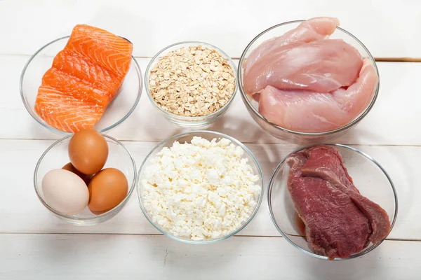 Белки, рыба, сыр, яйца, мясо и курица на белом деревянном фоне — стоковое фото