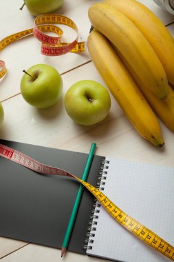 Beyaz ahşap bir masa meyve ve diyet planı