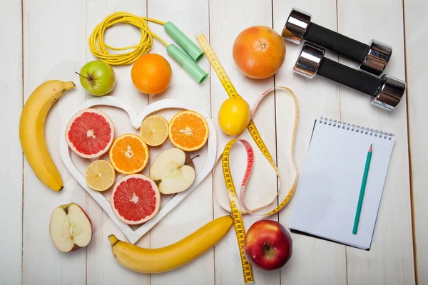 diet plan, dumbbells and centimeter on a white background