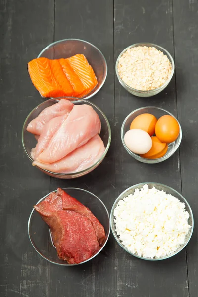 Proteins, fish, cheese, eggs, meat and chicken on a black background