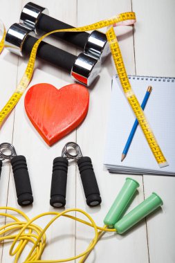 Kalp, halter, ip ve genişletici bir beyaz ahşap arka plan üzerinde atlama