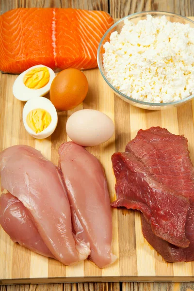 Dieta de proteína, peixe, queijo, ovos, carne e frango em um fundo de madeira — Fotografia de Stock