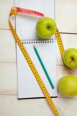 Beyaz ahşap bir masa kasette ölçme ile yeşil elma