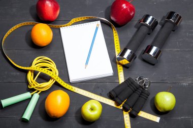 dambıl ve meyveler, fitness arka plan üzerinde siyah ahşap
