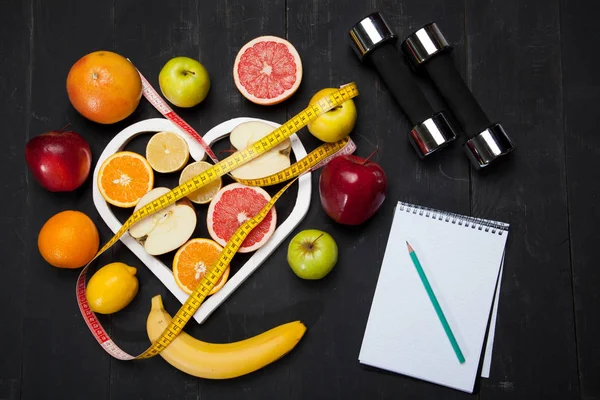 Diyet planı, meyve ve santimetre siyah bir zemin üzerine