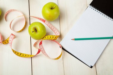 Beyaz ahşap bir masa kasette ölçme ile yeşil elma