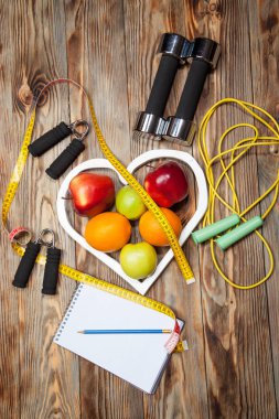 Beyaz kalp, elmalar ve Portakallar, beslenme, sağlıklı, dumbell a ahşap arka plan üzerinde ip atlama