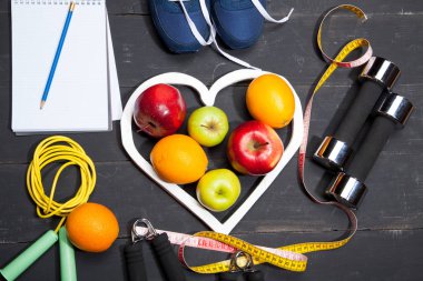 Kalp, meyve ve halter. Fitness, sağlıklı bir yaşam tarzı siyah ahşap zemin