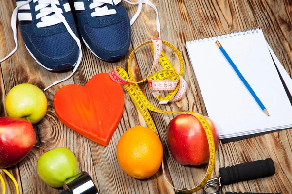 Сердце, яблоки и апельсины, диета, здоровье, гантели скакалку на деревянном фоне Стоковое Фото