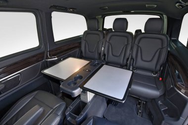 Rahat deri koltukları ve masası olan lüks bir minibüs.