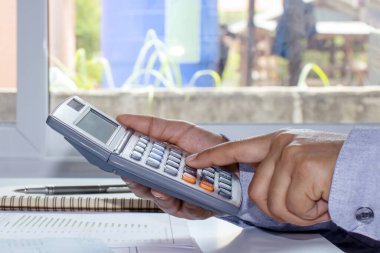 Masrafları hesaplamak, hesaplama kavramlarını hesaplamak ve gelecek için para biriktirmek için hesap makinesine basan bir kadının yakın plan çekimi.