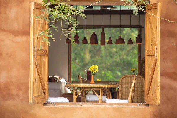 Yemek masası ve çiçek vazosuyla geleneksel yemek odasının pencereleri.