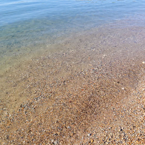 Schöner Hintergrund des blauen ruhigen Meeres mit kleinen Fischen, Sand und — Stockfoto