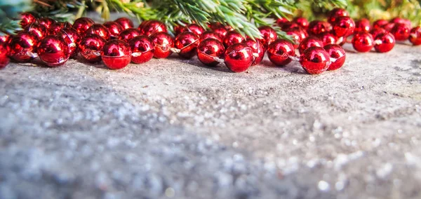 Red beads and conifer branches on a backdrop of rustic wood with — ストック写真