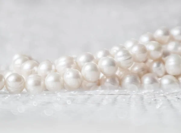 Nature white string of pearls on a sparkling background in soft focus, with highlights