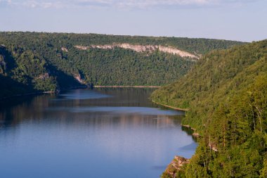 Dağların ortasında mavi göl ve günbatımında ormanlar..