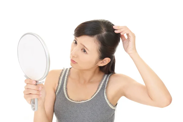 Kvinna som tittar missnöjd med hennes hår — Stockfoto