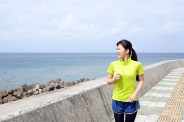 Genç kadın deniz kenarında koşu