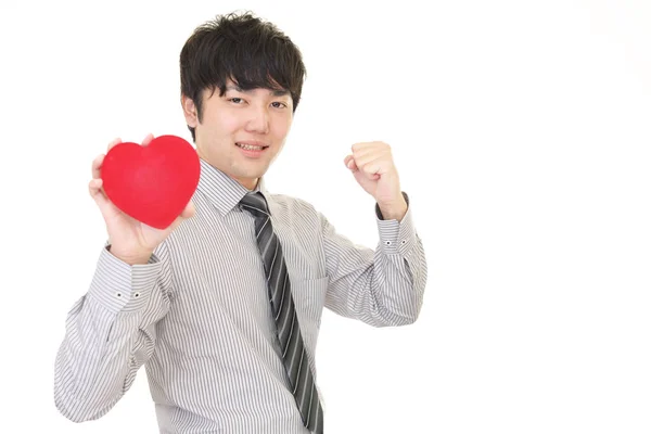 Homem sorridente com um coração vermelho — Fotografia de Stock