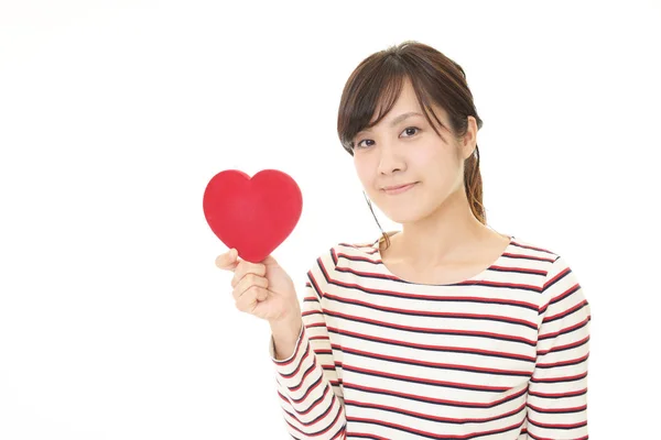 Mujer sonriente con un corazón rojo — Foto de Stock