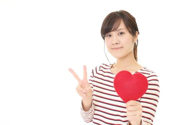 Mujer sonriente con un corazón rojo — Foto de Stock