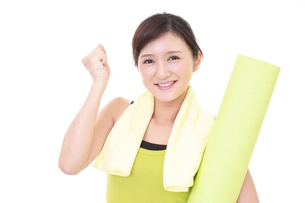 Женщина с ковриком для йоги в спортзале — стоковое фото