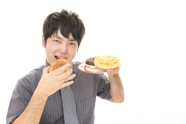 甘いものを食べる男 — ストック写真