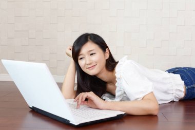 Gülümseyen kadın dizüstü bilgisayar kullanıyor.