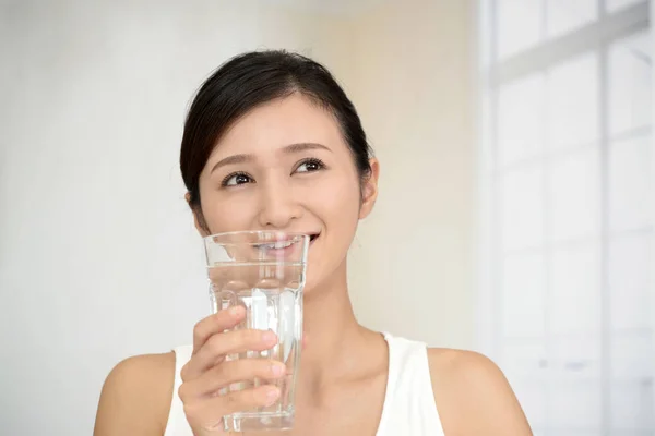 Vrouw die een glas water drinkt — Stockfoto